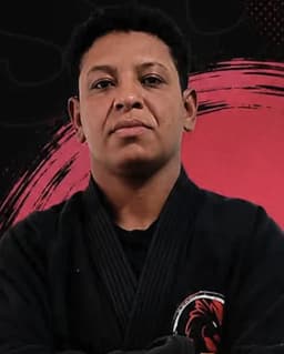 Instrutora Letícia de kimono preto e faixa marrom